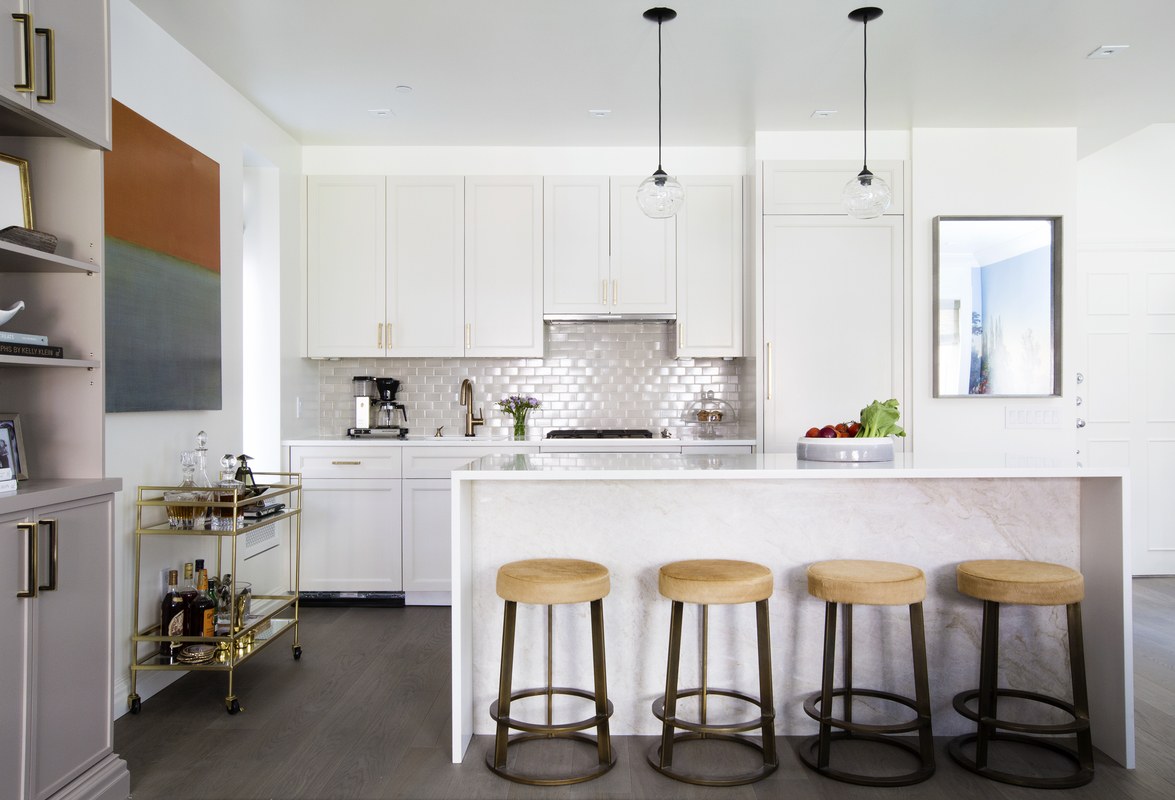 Architect Suzie Mariniello of MS Architecture & Design gutted the galley kitchen, opening up the space to a light-filled living and dining area. A painting by Leora Armstrong from Gerald Bland hangs above a brass bar cart.